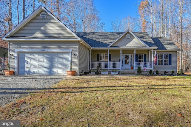 view of front facade featuring a garage, covered porch, a front lawn, and gravel driveway