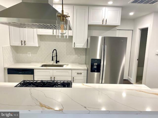 kitchen featuring stainless steel fridge, wall chimney exhaust hood, white dishwasher, sink, and white cabinets