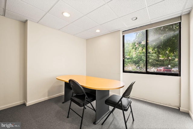 carpeted dining room with a paneled ceiling