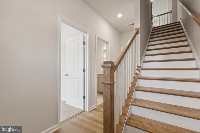 staircase with hardwood / wood-style floors