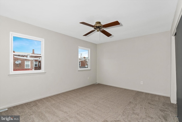 empty room with ceiling fan and light carpet