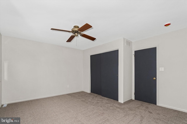 unfurnished bedroom featuring ceiling fan, a closet, and light colored carpet