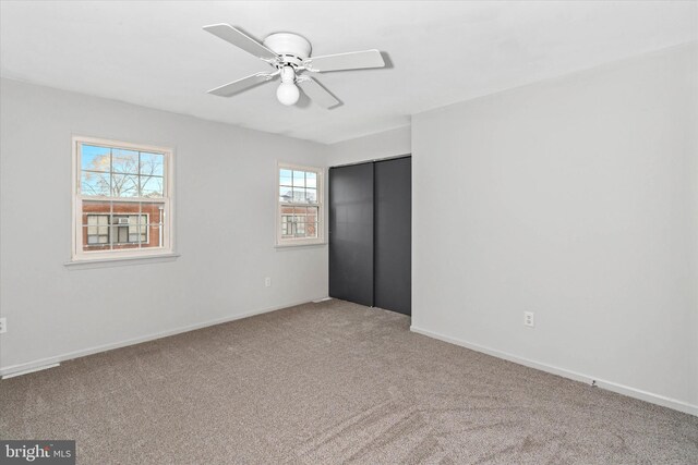 unfurnished bedroom with ceiling fan, a closet, and carpet