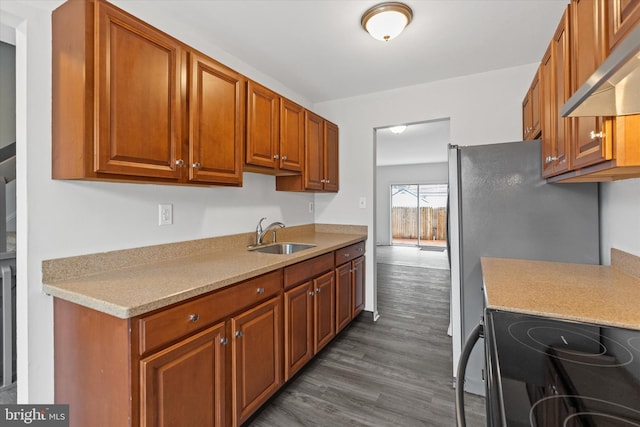 kitchen featuring range, sink, extractor fan, and dark wood-type flooring