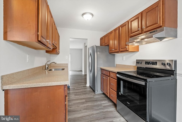 kitchen with sink, stainless steel appliances, and light wood-type flooring