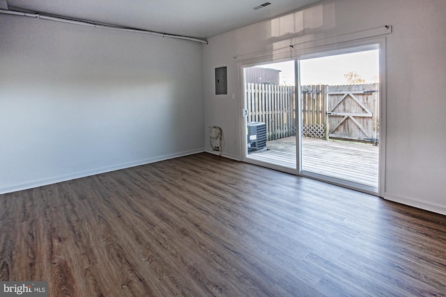 spare room featuring electric panel and dark wood-type flooring