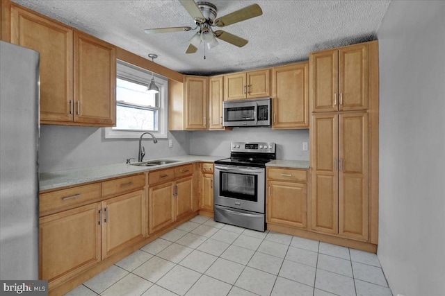 kitchen featuring a textured ceiling, stainless steel appliances, ceiling fan, sink, and light tile patterned flooring