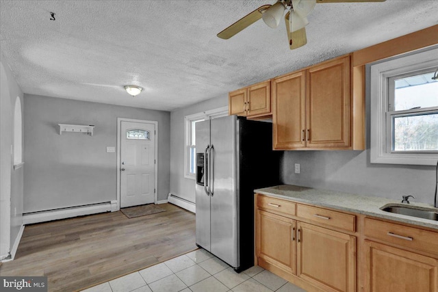 kitchen with a baseboard heating unit, a textured ceiling, and light hardwood / wood-style flooring