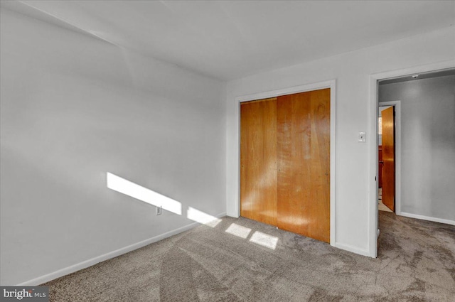 unfurnished bedroom featuring carpet floors and a closet