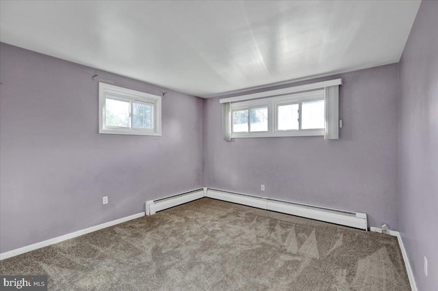 empty room with carpet flooring and a baseboard heating unit