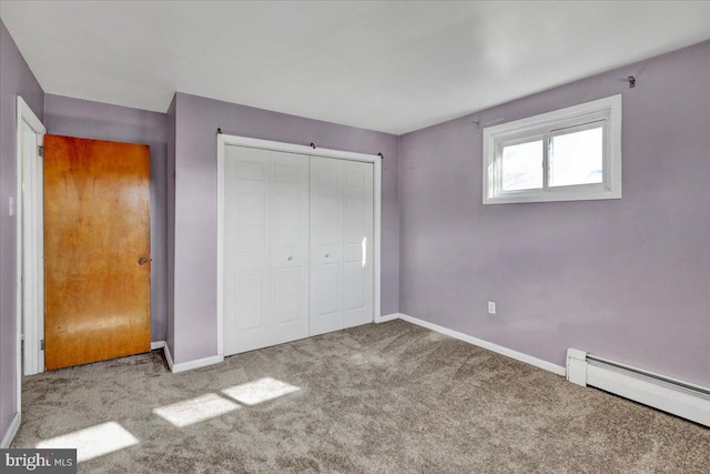 unfurnished bedroom featuring carpet floors, baseboard heating, and a closet