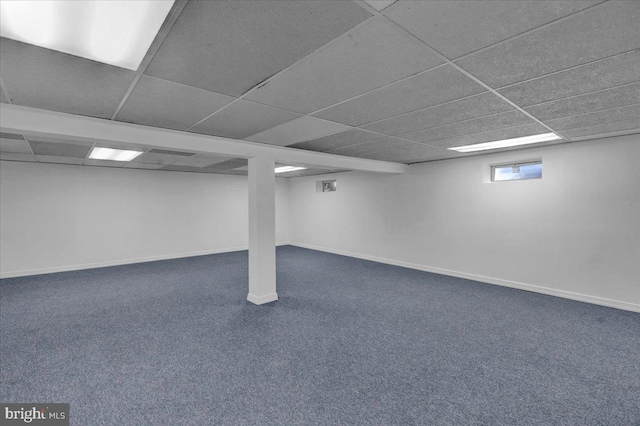 basement with dark colored carpet and a paneled ceiling