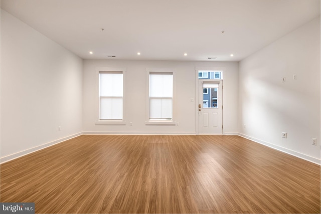 empty room featuring plenty of natural light and hardwood / wood-style flooring