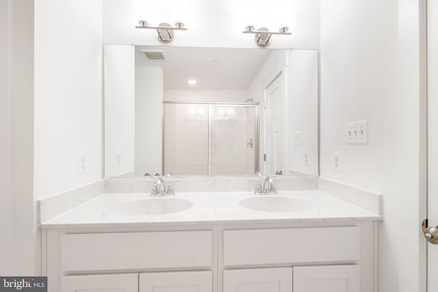 bathroom featuring vanity and a shower with shower door