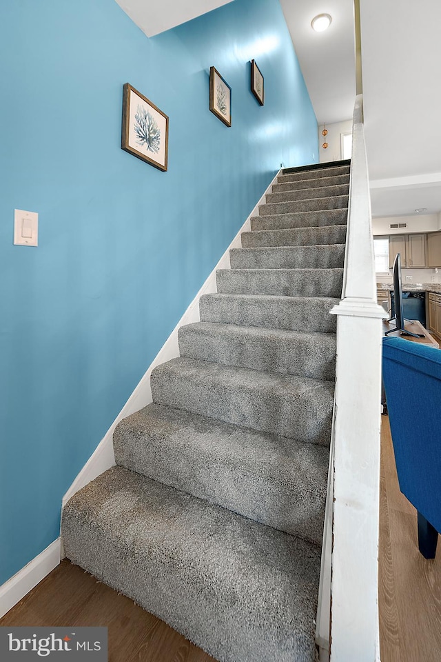 staircase with hardwood / wood-style flooring