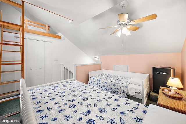 carpeted bedroom featuring a closet, lofted ceiling, and ceiling fan