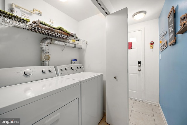 laundry area with independent washer and dryer and light tile patterned floors