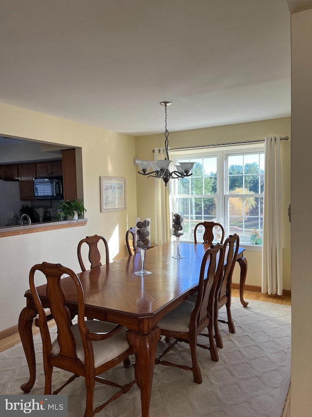 dining room featuring light wood-type flooring and a notable chandelier