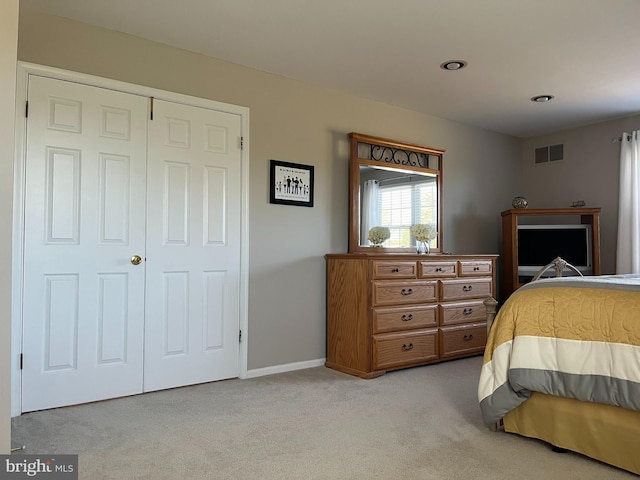 bedroom featuring light colored carpet and a closet