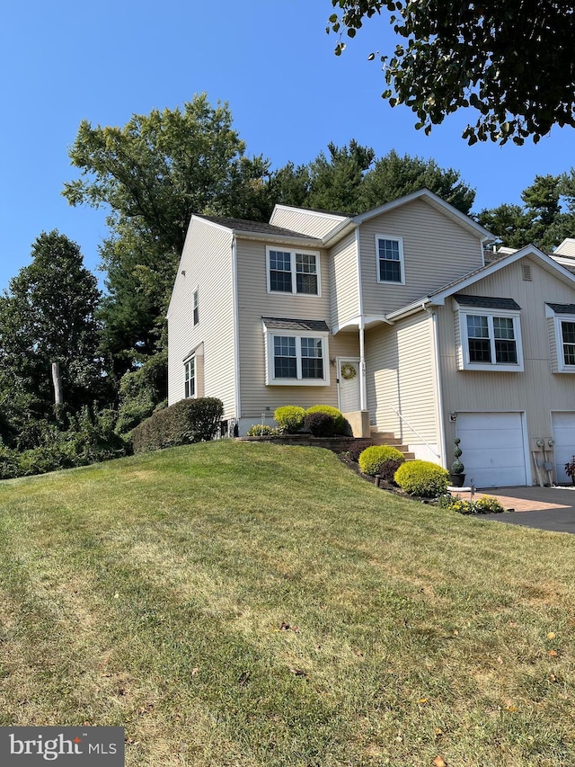 view of property with a garage and a front lawn