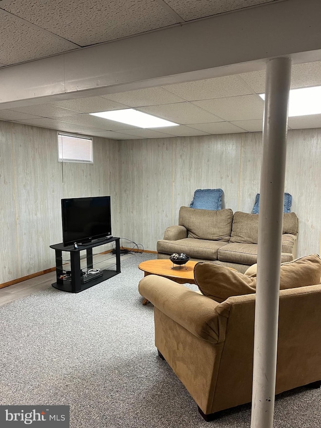 living room with a paneled ceiling and carpet flooring