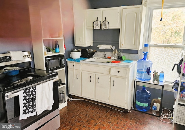 kitchen with sink, white cabinetry, and electric stove