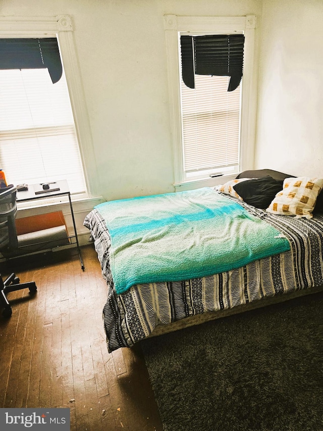 bedroom with wood-type flooring and multiple windows