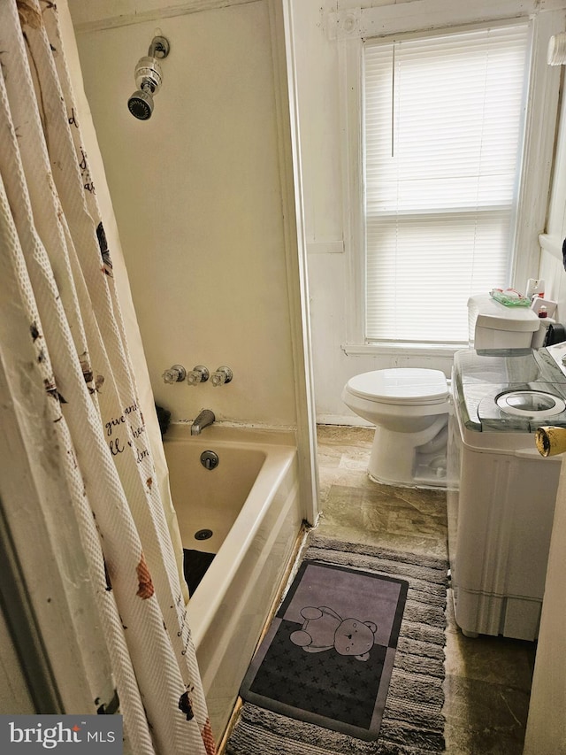 bathroom featuring shower / tub combo and toilet