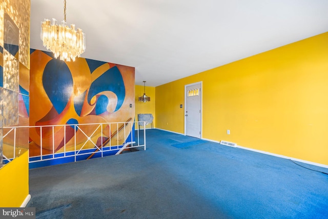 carpeted empty room featuring a notable chandelier