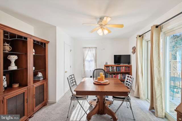 carpeted dining space featuring ceiling fan and a healthy amount of sunlight