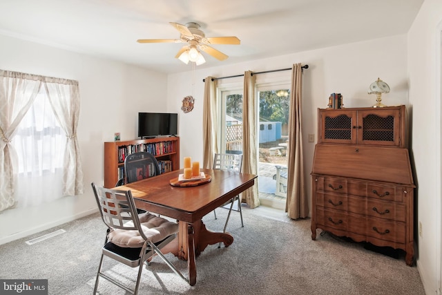 dining area featuring light carpet and ceiling fan