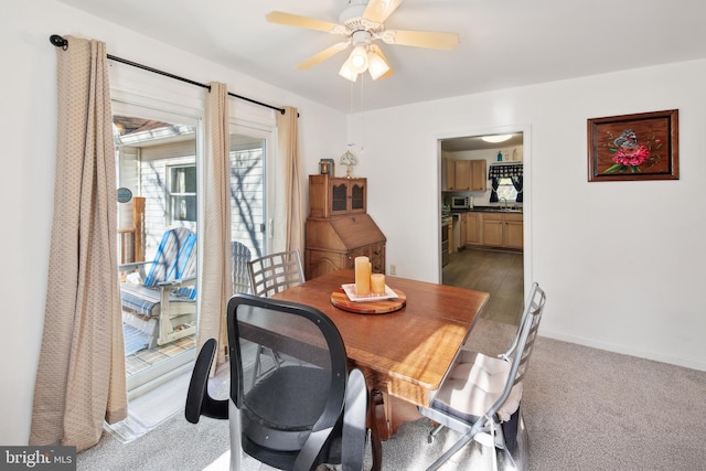 carpeted dining space with ceiling fan and sink