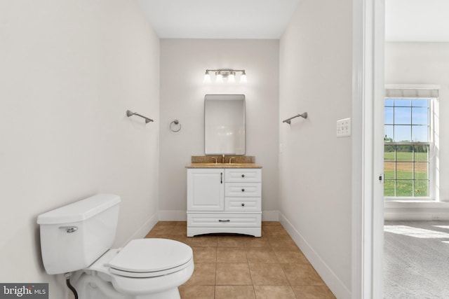 bathroom featuring toilet, baseboards, tile patterned floors, and vanity