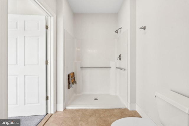 bathroom featuring a shower, tile patterned floors, and toilet