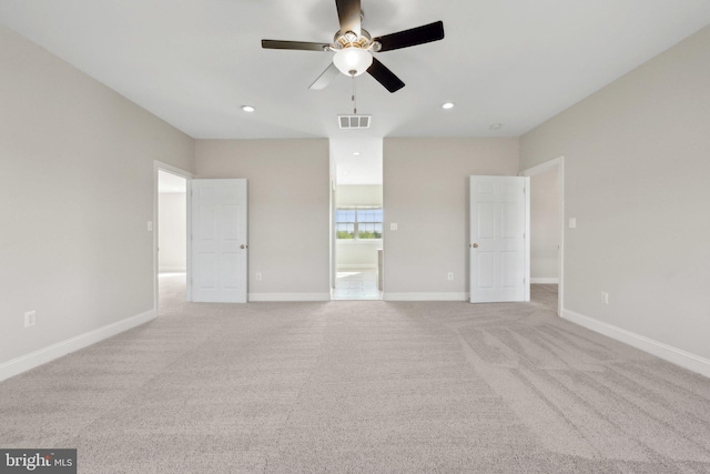 empty room featuring visible vents, a ceiling fan, baseboards, and light carpet