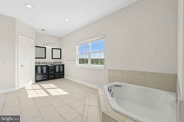 bathroom with double vanity, a garden tub, visible vents, tile patterned flooring, and baseboards