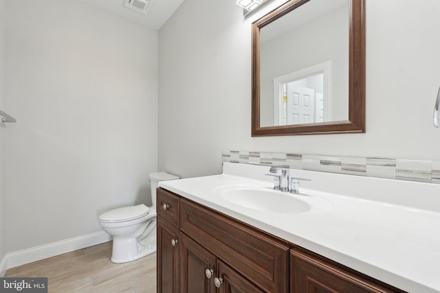 bathroom with toilet, baseboards, visible vents, and vanity