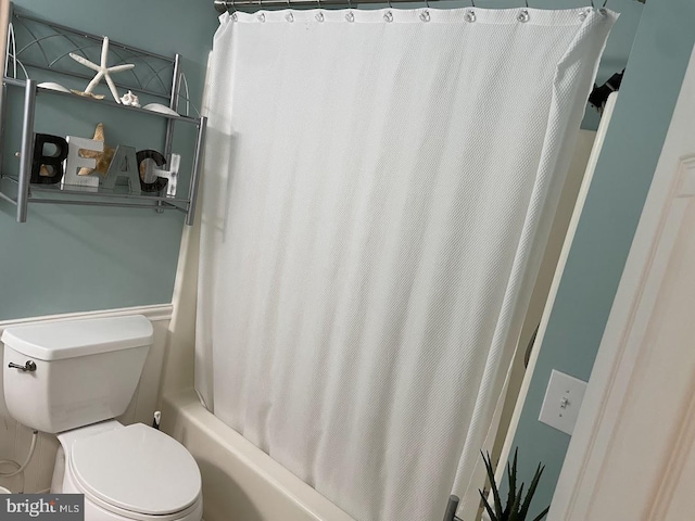 bathroom featuring toilet and shower / bathtub combination with curtain