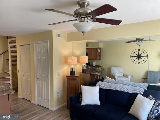 living room featuring ceiling fan and light hardwood / wood-style flooring