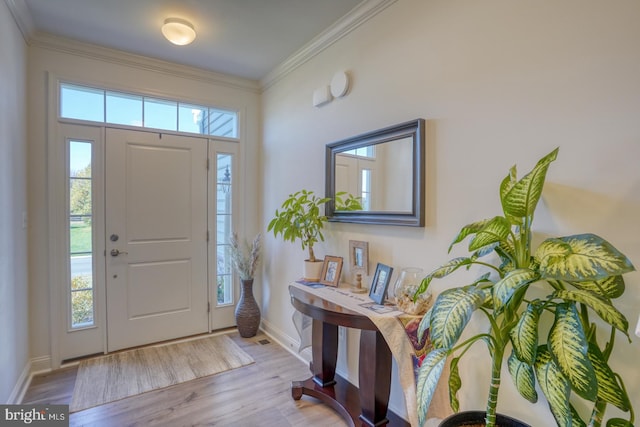 foyer entrance with light wood-type flooring and ornamental molding