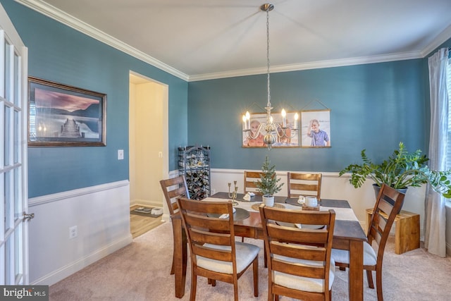 carpeted dining space featuring a notable chandelier and ornamental molding