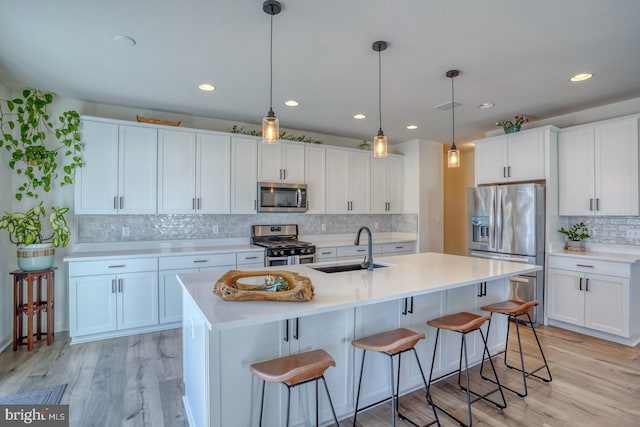 kitchen with white cabinets, sink, light wood-type flooring, and stainless steel appliances