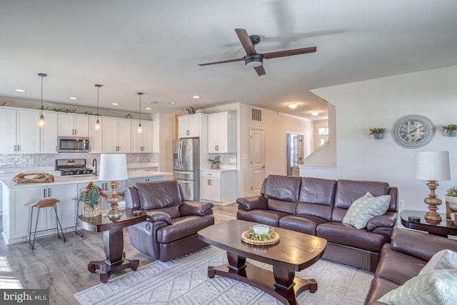 living room with ceiling fan and light hardwood / wood-style floors