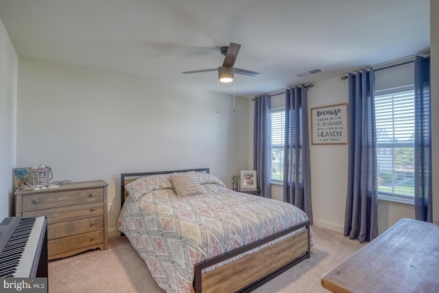 bedroom featuring light carpet, multiple windows, and ceiling fan