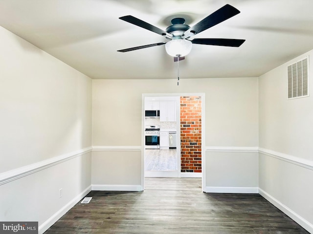 empty room with ceiling fan and dark wood-type flooring