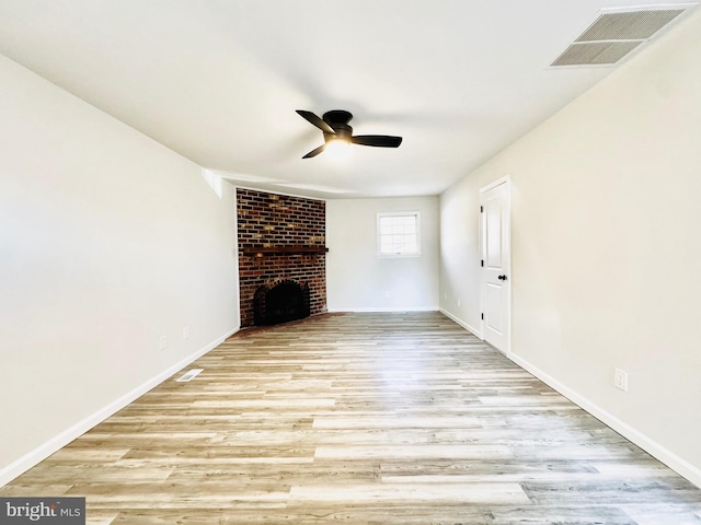 unfurnished living room featuring ceiling fan, a fireplace, and light hardwood / wood-style flooring