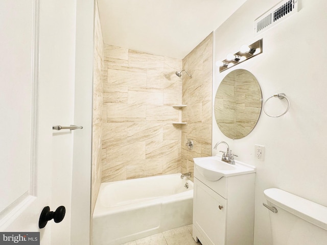 full bathroom with tile patterned flooring, vanity, tiled shower / bath combo, and toilet