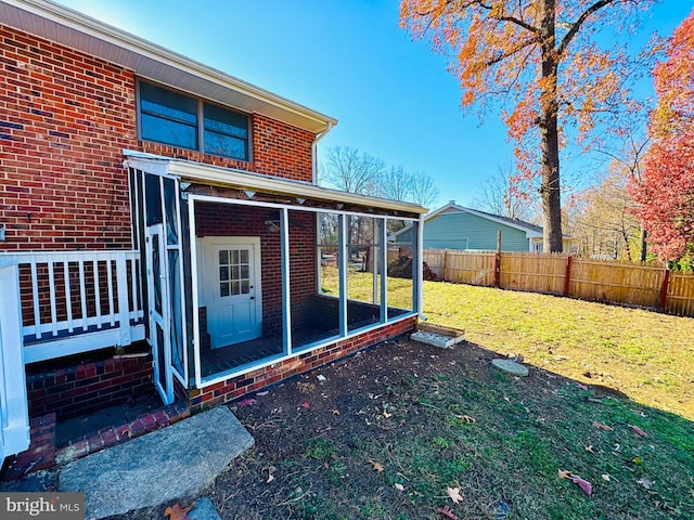 back of house with a sunroom and a yard