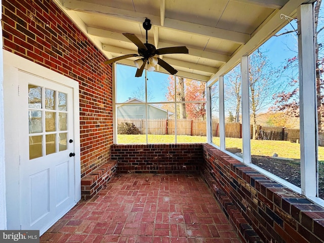 unfurnished sunroom with ceiling fan and beamed ceiling