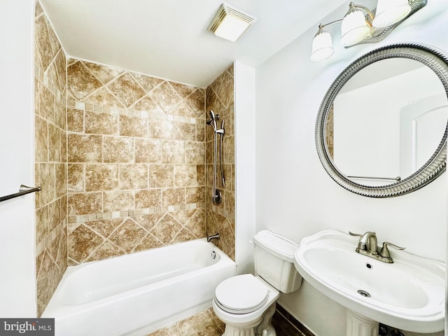 full bathroom with toilet, tiled shower / bath, and sink